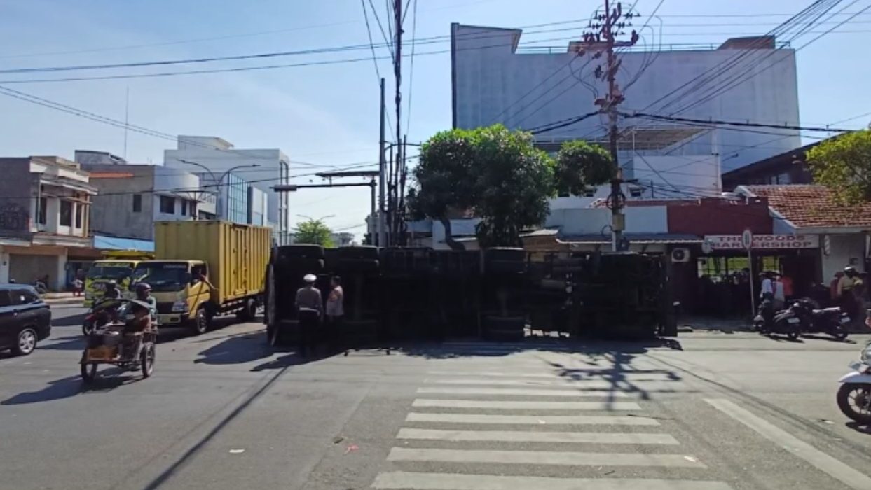 Badan truk muatan garam yang dikemudikan Udas Warga Jombang 21 tahun terguling di Simpang Kapasan.