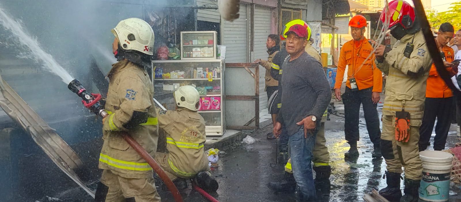 Petugas Dinas Pemadam Kebakaran dan Penyelamatan Kota Surabaya saat melakukan penanganan kebakaran kios buah di Pasar Darmo Permai Timur, Surabaya.