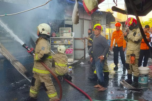 Petugas Dinas Pemadam Kebakaran dan Penyelamatan Kota Surabaya saat melakukan penanganan kebakaran kios buah di Pasar Darmo Permai Timur, Surabaya.