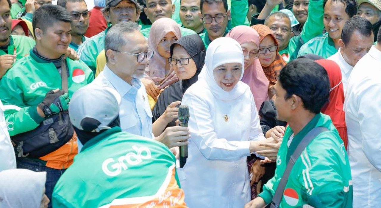 Gubernur Jawa Timur Khofifah Indar Parawansa bersama Menteri Koordinator (Menko) Bidang Pangan Republik Indonesia Zulkifli Hasan (Zulhas) salurkan paket sembako kepada pengemudi ojek daring (ojol) di GOR Tri Dharma Petrokimia Gresik, Rabu (15/7/2026).