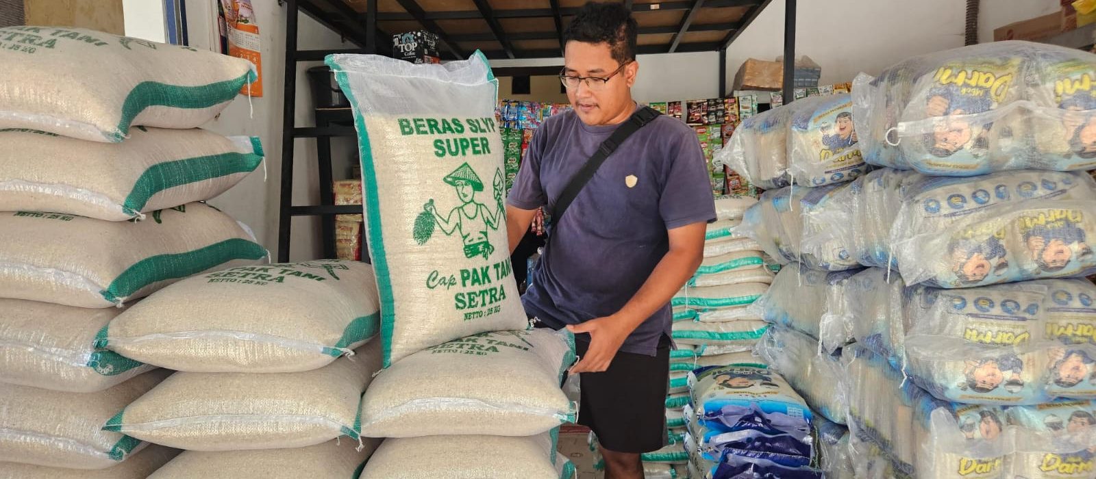 Pedagang menunjukkan stok beras di Pasar Pagotan, Kabupaten Madiun. Kenaikan harga gabah mendorong harga beras medium dan premium ikut naik.