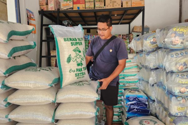 Pedagang menunjukkan stok beras di Pasar Pagotan, Kabupaten Madiun. Kenaikan harga gabah mendorong harga beras medium dan premium ikut naik.
