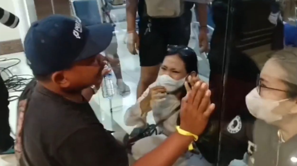 Penuh haru, seorang korban selamat KMP Mutiara Santosa II bertatapan dengan keluarga yang telah menunggu melalui kaca ruang tunggu di Gapura Surya Nusantara (GSN), Pelabuhan Tanjung Perak, Surabaya.