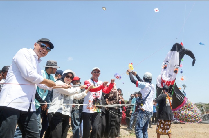 Eri Cahyadi dan istri mencoba menerbangkan layang-layang hias Punakawan dalam Kite Festival 2026.