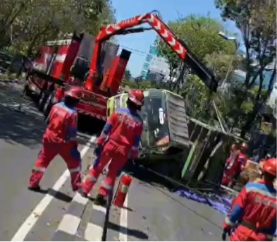 Petugas mengevakuasi truk ekspedisi bermuatan ratusan paket sepeda angin yang terguling di Jalan Raya Dupak, Surabaya.