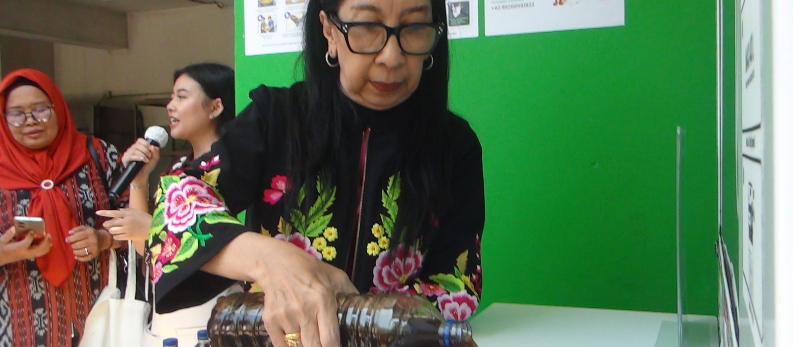 Salah satu warga menuangkan minyak jelantah ke Reverse Vending Machine U Collect.