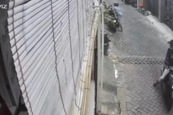 Rekaman CCTV di Margorukun memperlihatkan satu pelaku curanmor beraksi mengenakan kaos biru, sementara pelaku lainnya yang mengenakan topi mengamati situasi.