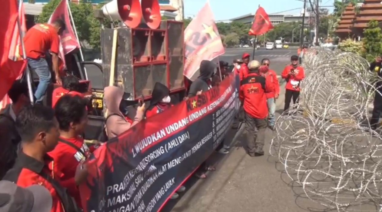 Puluhan massa KASBI menggelar demonstrasi terkait sistem ketenagakerjaan di depan Gedung DPRD Jatim.