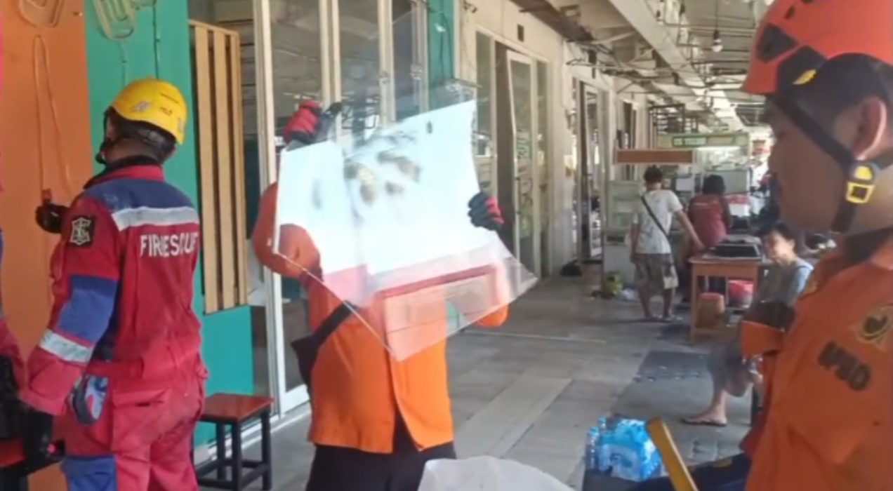 Petugas membersihkan pecahan kaca dari lokasi ledakan di kawasan Ruko San Antonio.