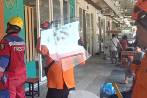 Petugas membersihkan pecahan kaca dari lokasi ledakan di kawasan Ruko San Antonio.