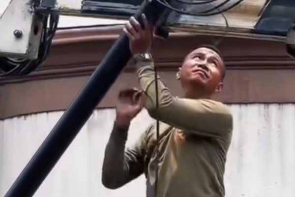 Petugas Satpol PP menurunkan tiang provider yang melanggar aturan di salah satu lokasi sasaran penertiban.